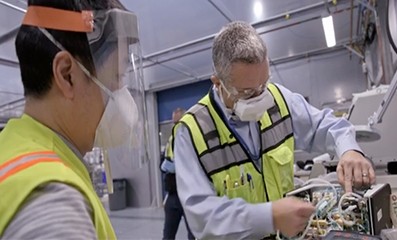 Two men working on a ventilator